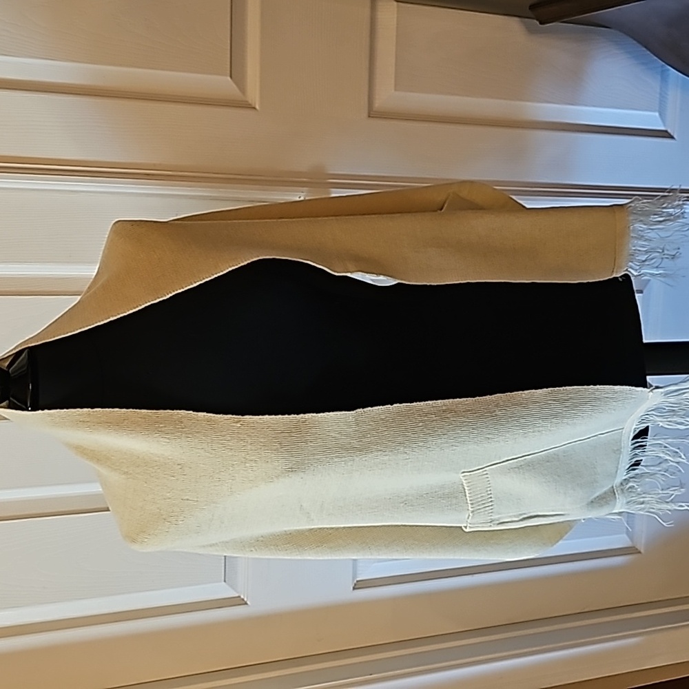 Beige shawl, knit with big pockets and fringe.